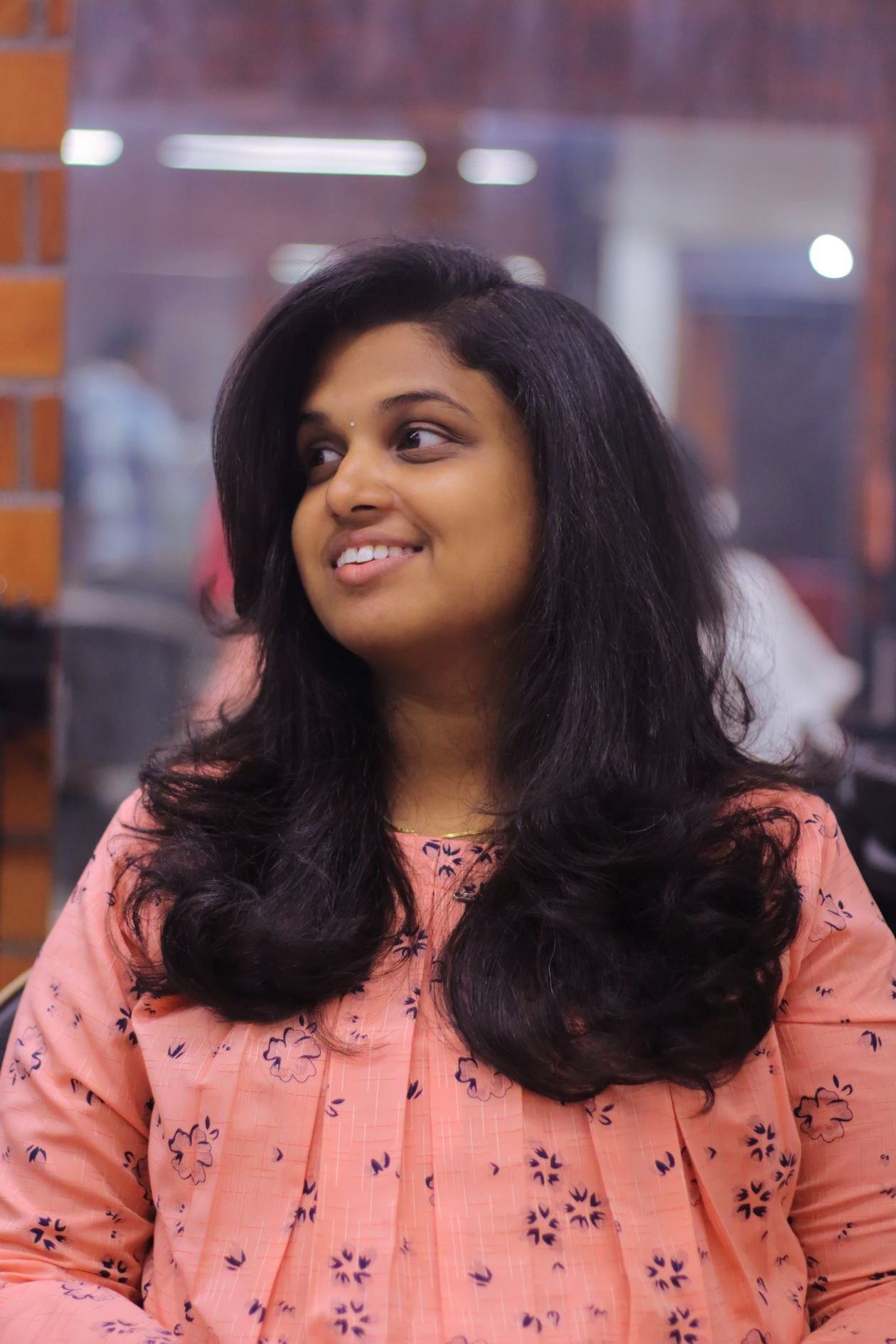 Young woman with soft face-framing layers smiling in a hair salon